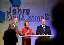 Landeshauptfrau Johanna Mikl-Leitner im Bühneninterview beim Festakt „10 Jahre MedAustron“, flankiert von (v.l.) Bürgermeister Klaus Schneeberger und Bundeskanzler Christian Stocker.